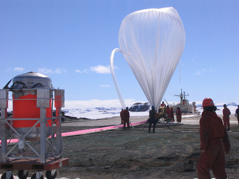 図1: 南極昭和基地における成層圏大気採集実験の放球作業の様子クライオジェニックサンプラー(左手前)の重量は350kgあり、これを成層圏の高度35kmまで上昇させるためには容積30,000立方ｍの大気球が必要です。大気球にはヘリウムガスが注入されます。
